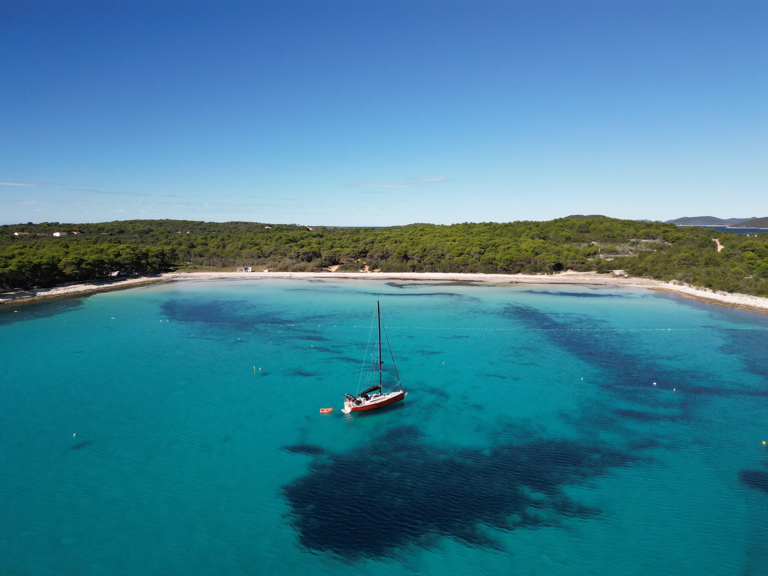 Performanceyacht Kultfabrik liegt vor Anker in einer Türkisblauen Bucht