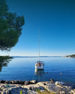 Eine Segelyacht liegt in einer schönen Bucht vor Anker