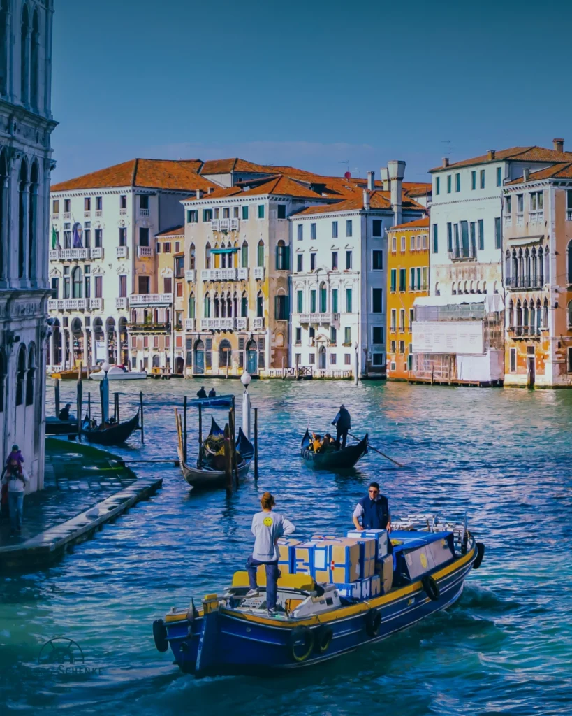 Gondoliere in Venedig im Kanal, Häuser im Hintergrund